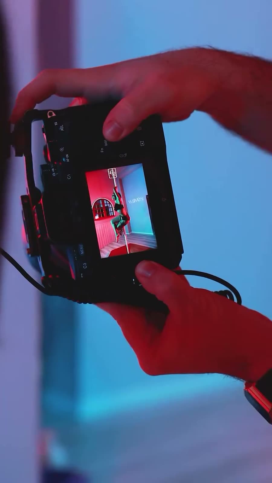 Mani di Giorgia Sofia che inquadrano la scena dietro una fotocamera: il dietro le quinte dello shooting.