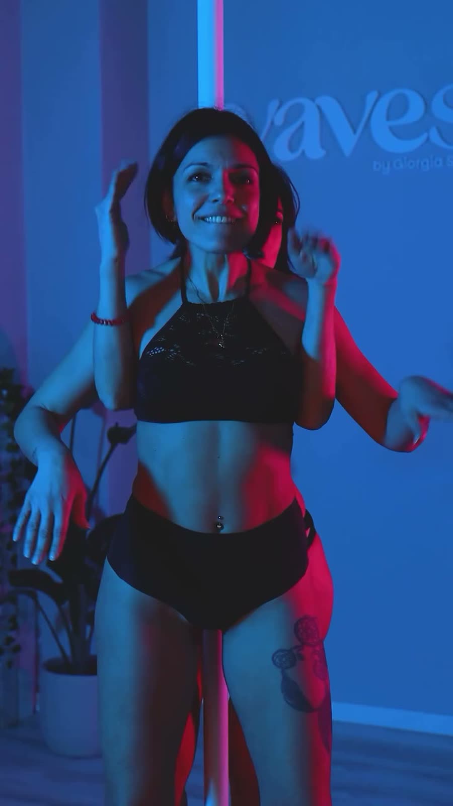 Ritratto frontale di un'allieva sorridente: blu e magenta sul viso, espressione naturale, non posata.